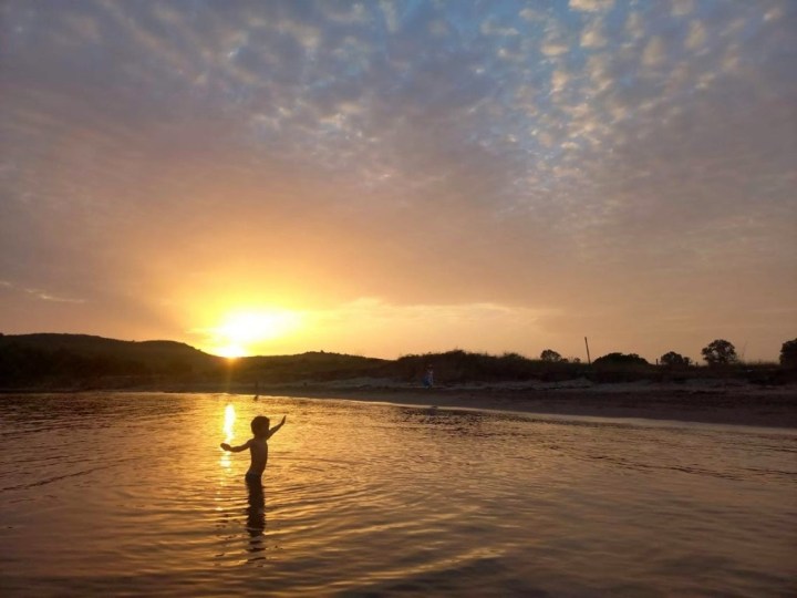 Copil pe plajă în Albania, la apus