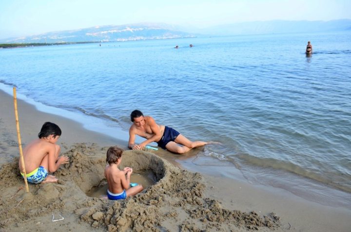 Familie se joacă pe plaja cu nisip Zvernec, lângă Vlore, Albania