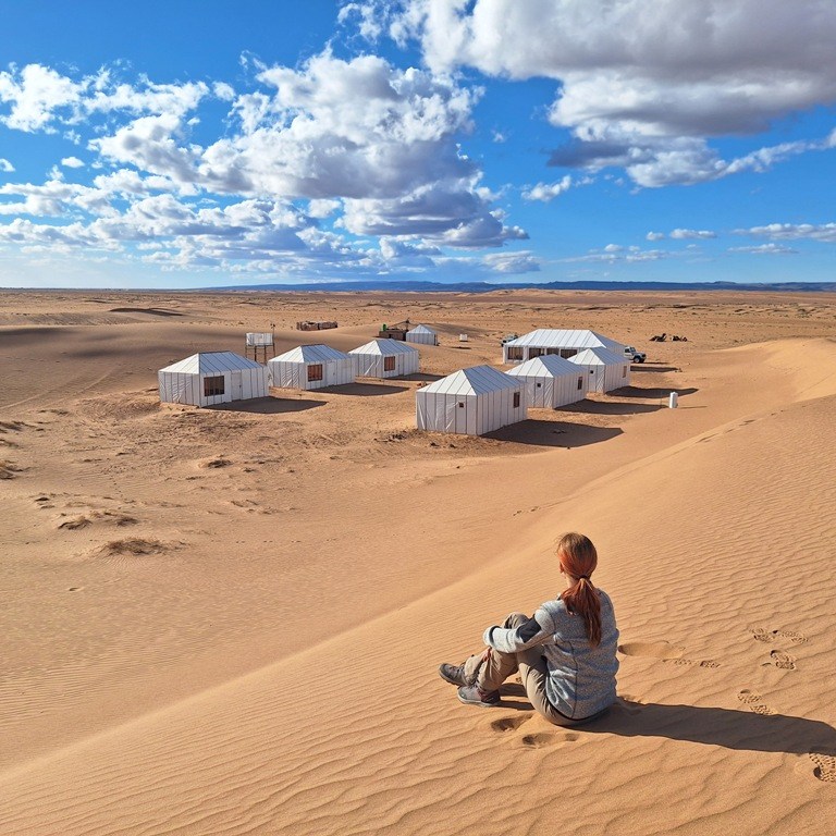 Woman looking at a traditional amazigh berber camp in Sahara
