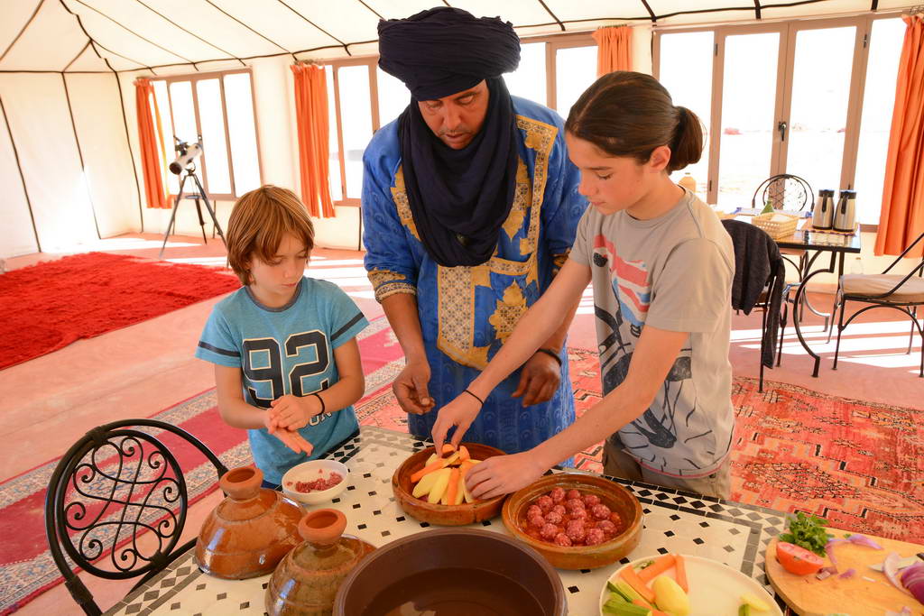 copii gatind tajine in desertul din Maroc, experienta traditionala berbera